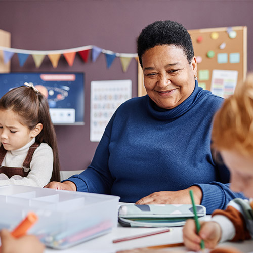 teacher watching her student color