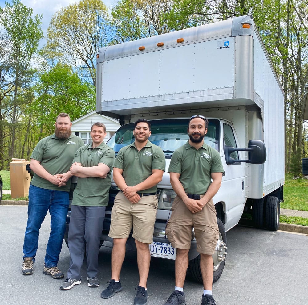 Moving crew taking a break on the tailgate of the truck