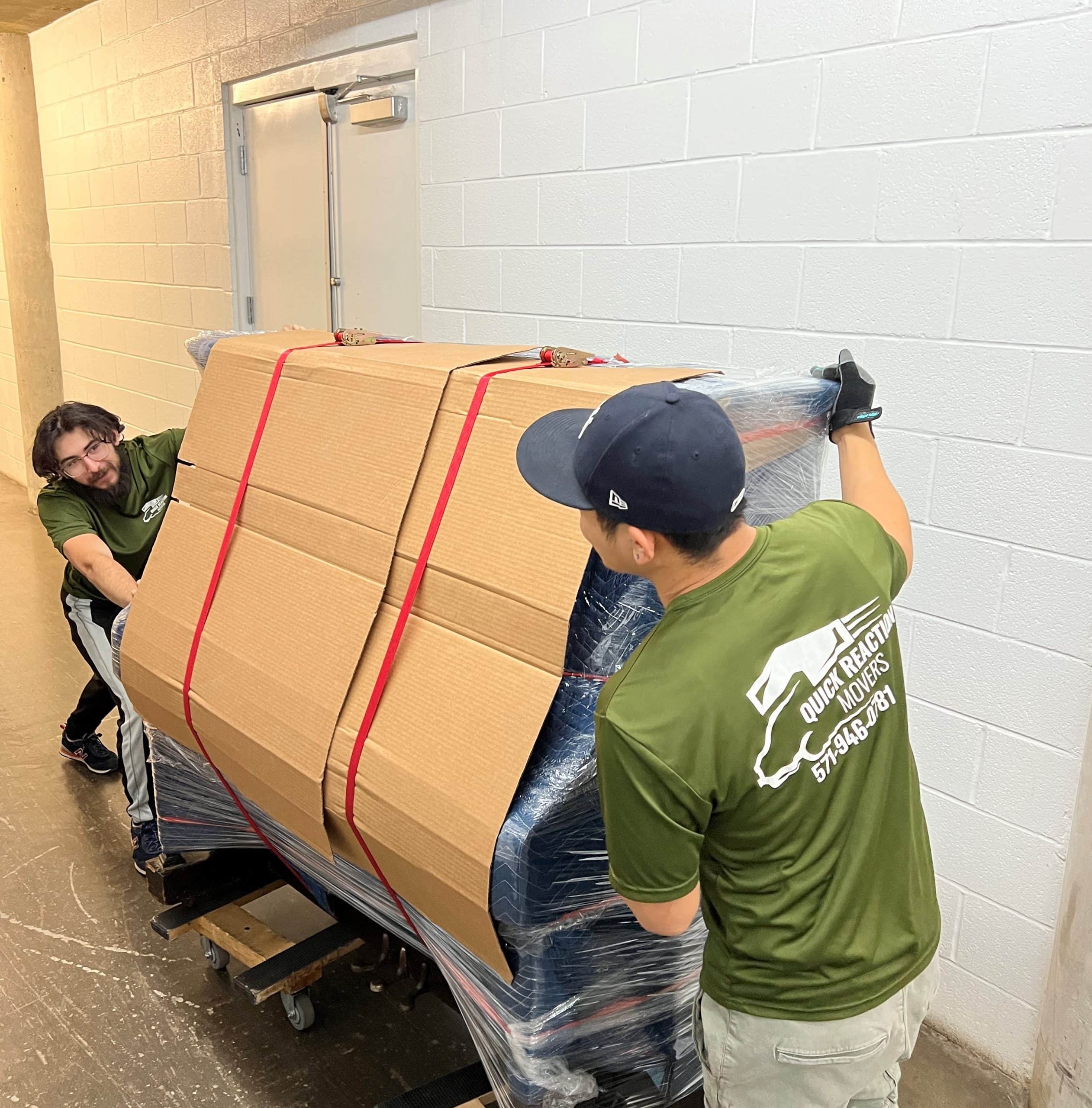 Mover carrying moving boxes down a hallway