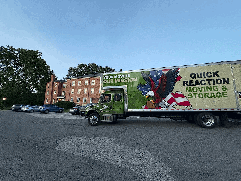 Quick Reaction moving truck parked beside a brick building